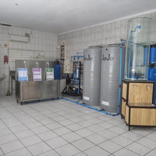 A customer-facing refill counter alongside water storage and treatment equipment.
