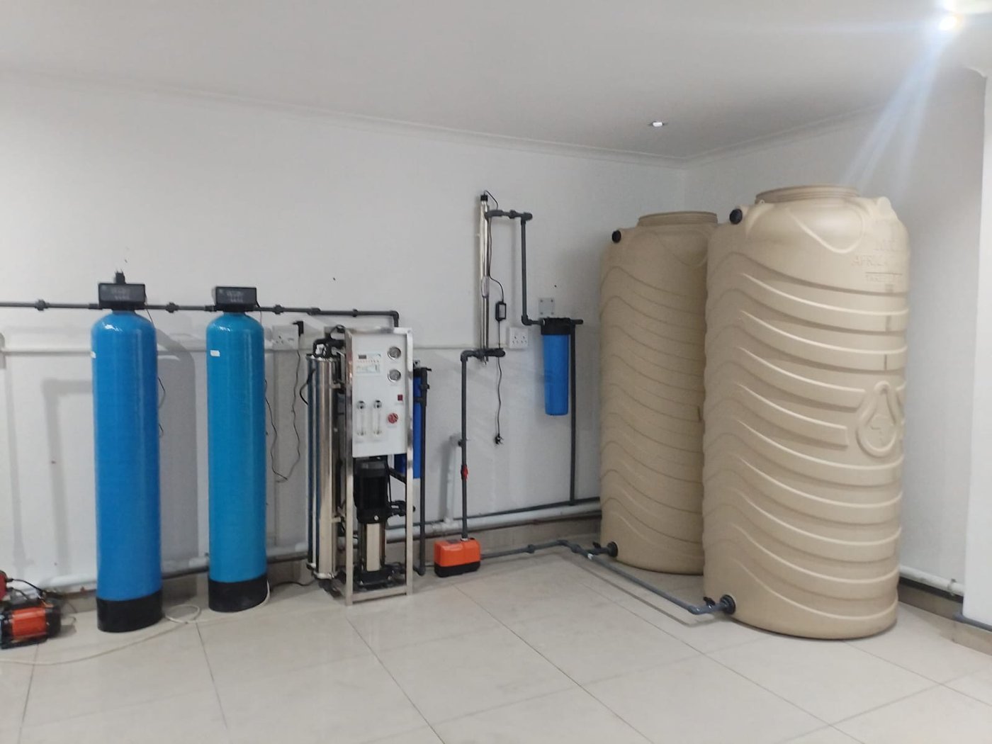 Blue filter vessels, a treatment unit and two storage tanks brought together in one indoor installation.